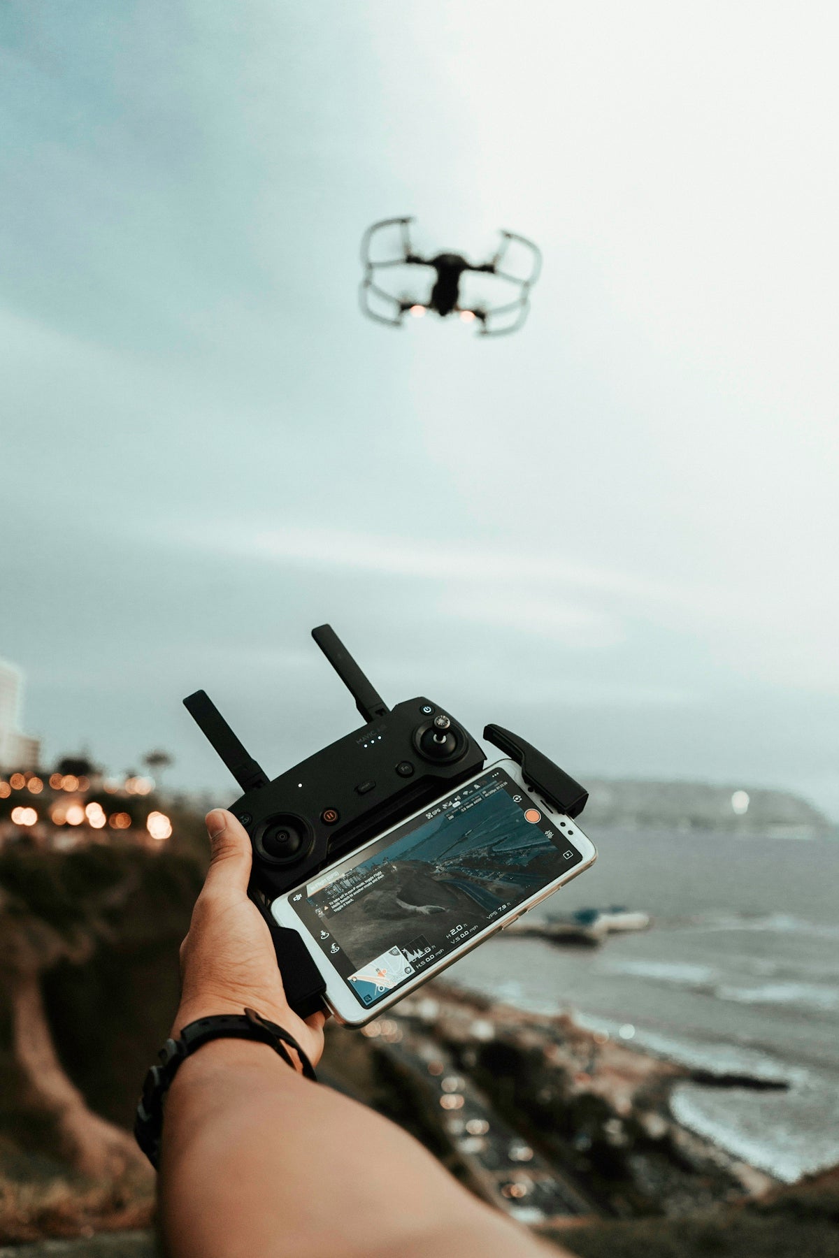 person using smartphone with gamepad controlling drone